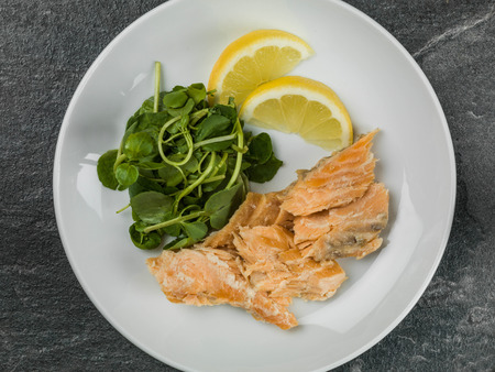 Poached Salmon and Watercress Salad Against a Black Background