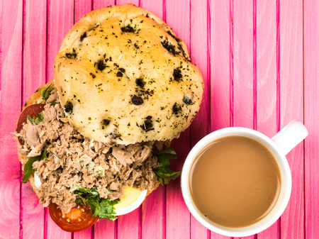 Tuna Nicoise Salad In a Focaccia Bread Bun Against a Pink Backgroundの写真素材