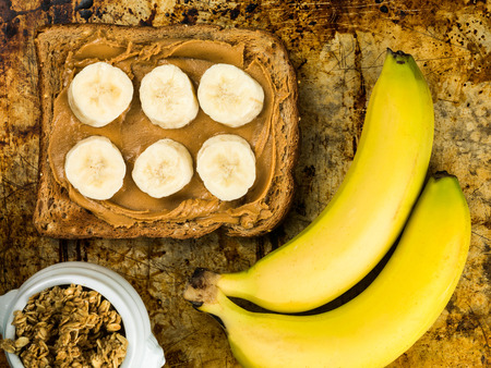 Sliced Banana and Peanut Butter on Wholegrain Toast On An Oven Trayの写真素材
