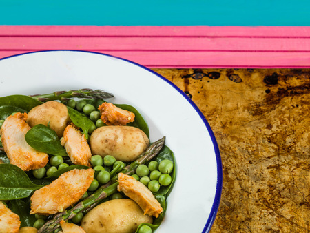Chicken Salad With Asparagus Peas Spinach and Potatoes Sitting on an Oven Trayの写真素材