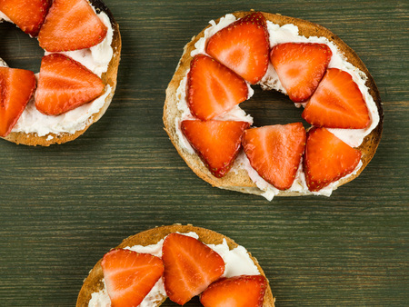 Fresh Strawberries and Cream Cheese On a Bagel Against a Green Backgroundの写真素材