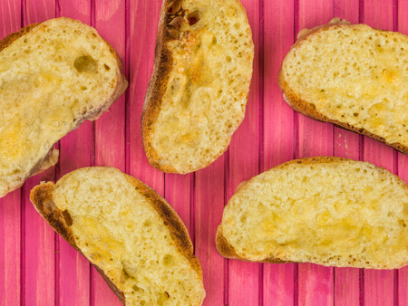 Melted Cheese on Toasted Ciabatta Bread Against a Pink Wooden Background