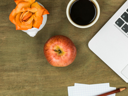 Computer Workstation with an Apple and a Cup of Black Coffee On A Distressed Wooden Desk Topの写真素材