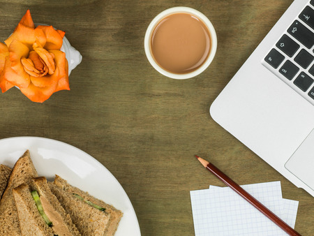Salmon and Cucumber Brown Bread Sandwich with a Cup of Tea At A Computer Workstationの写真素材
