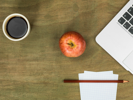 Computer Workstation with an Apple and a Cup of Black Coffee On A Distressed Wooden Desk Topの写真素材