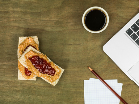 Peanut Butter and Jam or Jelly With A Cup of Black Coffee At A Computer Workstationの写真素材