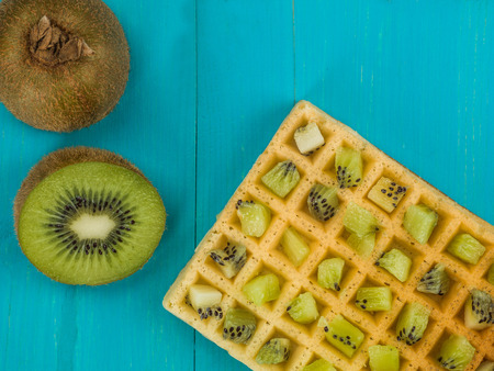 Kiwi Fruit on a Toasted Waffle Against a Blue Wooden Backgroundの写真素材