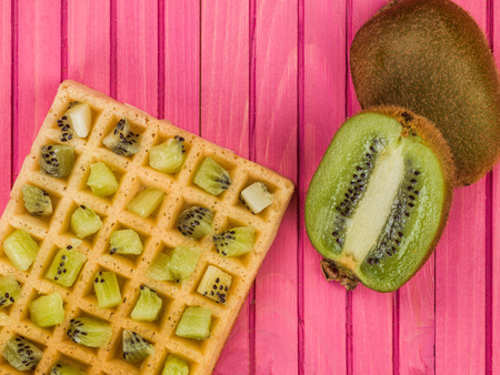 Kiwi Fruit on a Toasted Waffle Against a Pink Wooden Backgroundの写真素材