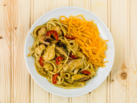 Chicken Katsu Curry Noodles With Chilli Against a Light Pine Wood Backgroundの写真素材