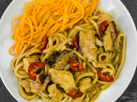 Chicken Katsu Curry Noodles With Chilli Against a Black Slate Tile Backgroundの写真素材