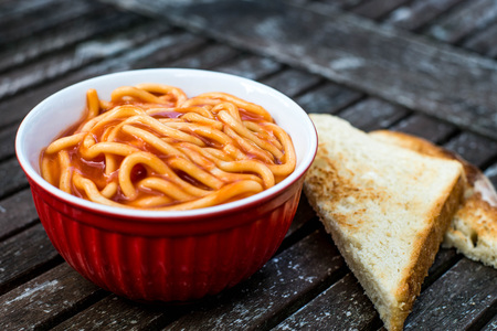Bowl of Spaghetti in Tomato Sauce Against a Dark Weathered Table Top