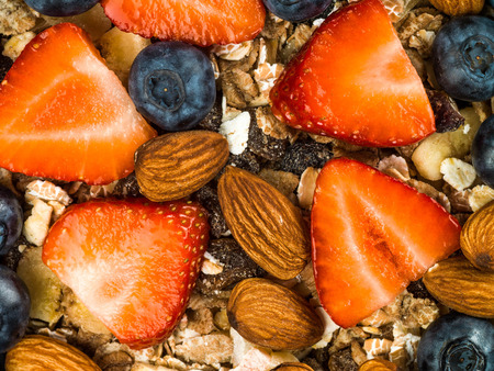 Breakfast Muesli Cereals With Strawberries and Blueberries Fruit Against a Green Backgroundの写真素材
