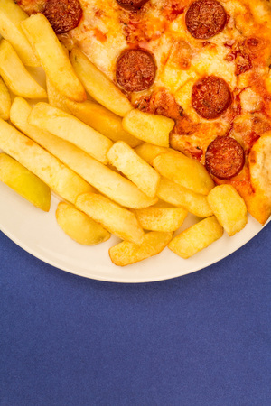 Italian Style Pepperoni Pizza With Chips Against A Blue Backgroundの写真素材