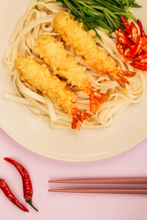 Japanese Style Tempura Prawns With Udon Noodles Chilli and Spring Onions Against A Lilac Backgroundの写真素材