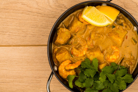 Sri Lanka Style King Prawn Curry With Lemon and Coriander Herbs On A light Wooden Tabletopの写真素材