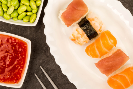 Japanese style prawn, salmon and tuna Nigiri sushi against a gray backgroundの写真素材