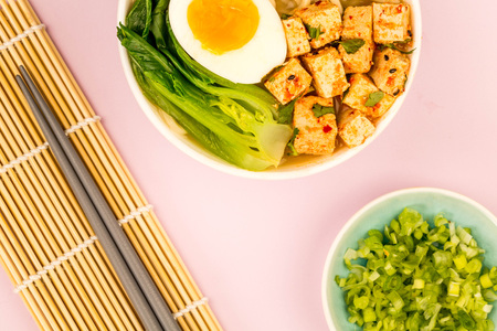 Japanese Style Vegetarian Tofu Noodle Ramen Soup or Broth Against A Pale Pink Backgroundの写真素材