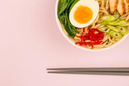 Japanese Style Chicken and Udon Noodle Broth or Soup With Pak Choi And Red Chillies Against A Pink Backgroundの写真素材