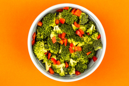 Vegetarian or Vegan Food Bowl Of Broccoli And Chilli Against An Orange Backgroundの写真素材