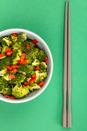 Vegetarian or Vegan Food Bowl Of Broccoli And Chilli Against A Green Backgroundの写真素材