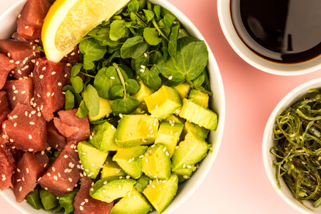 Hawaiian Style Tuna And Avocado Sashimi Poke Food Bowl Against A Light Pink Backgroundの写真素材