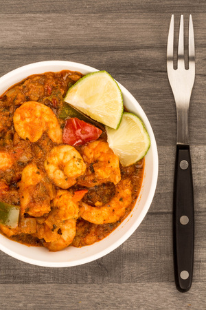 Spicy Indian Style King Prawn Bhuna Curry Against A Dark Wooden Kitchen Table Topの写真素材