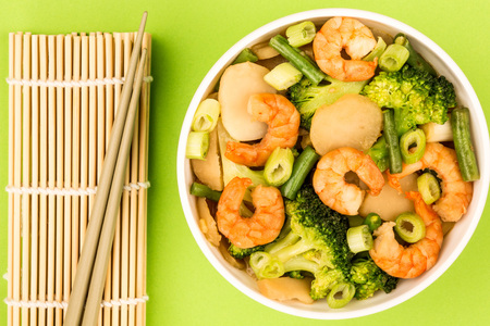 Chinese Style King Prawn With Ginger Broccoli And Spring Onions Against A green Backgroundの写真素材