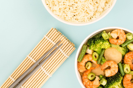 Chinese Style King Prawn With Ginger Broccoli And Spring Onions Against A Blue Backgroundの写真素材