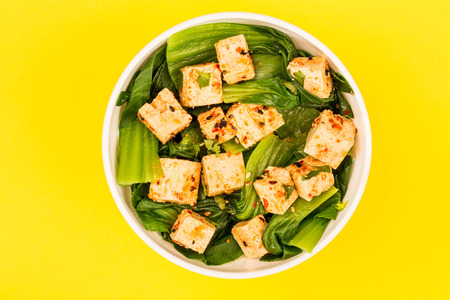 Chinese Style Pak Choi With Tofu Against A Yellow Backgroundの写真素材