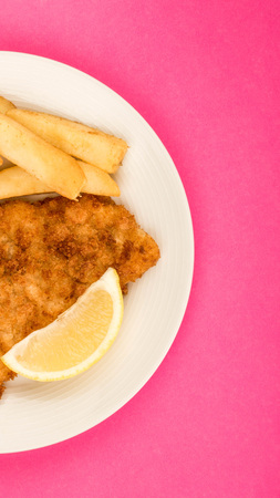 Traditional Popular Fish And Chips Against A Pink Backgound With A Slice Of Lemonの写真素材
