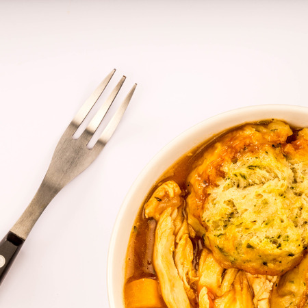 Traditional Chicken And Dumpling Casserole Against A Pale Blue Pastel Backgroundの写真素材