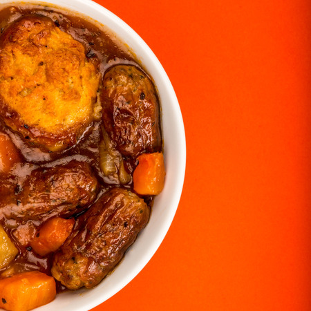 Traditional British Lincolnshire Sausage Cobbler Against A Red Backgroundの写真素材
