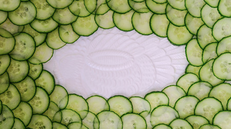 Thin Slices of Cucumber Arranged on a White Plateの写真素材
