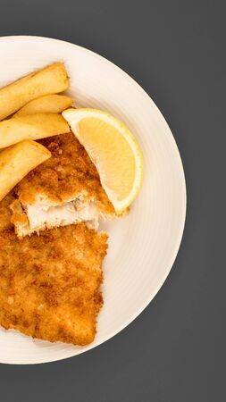 Traditional Popular Fish And Chips Against A Grey Background With A Slice Of Lemonの写真素材