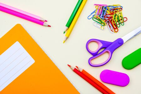 Back To School Workbook or Exercise Book and Coloured Pencils With Rubbers and Paperclipsの写真素材