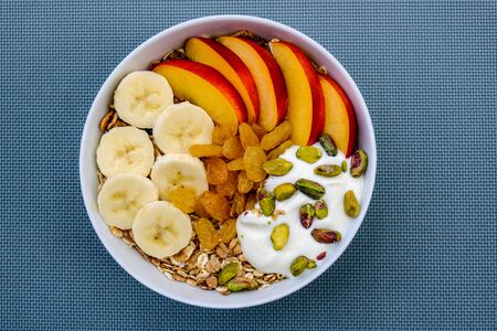 Healthy Vegetarian Breakfast Bowl of Muesli Fruit and Nuts With Yogurt and Golden Sultanas