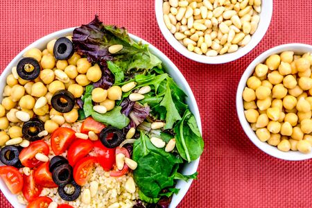 Vegetarian Bulgur Wheat Lunch Bowl With Chickpeas, Black Olives, Tomatoes, Green Leaves Salad and Pine nutsの写真素材