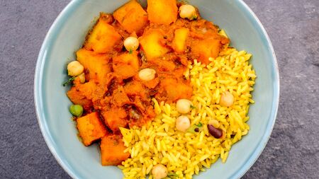 Indian Style Spicy Traditional Potato Vegetarian Curry With Yellow Pilau Rice and Chickpeas