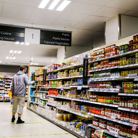 Stacked Shelves With A Selection Of Foods In John Lewis Waitrose, With An Anonymous Male Shopperのeditorial素材