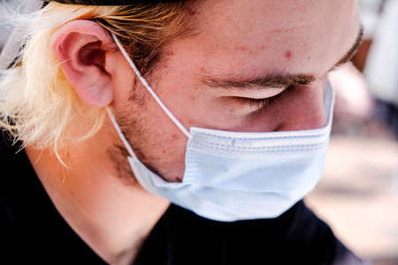 Anonymous Young Man Wearing A Protective Face Covering During COVID 19 Pandemic 2020のeditorial素材