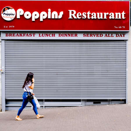Woman Walking Past A Closed Independent Cafe Talking On Her Smartphone Dshopper, consumer, walk, during The Coronavirus Pandemic In The UKのeditorial素材