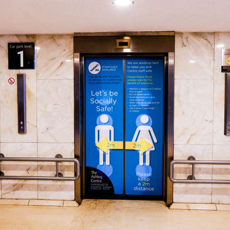 South London Shopping Centre Lift Doors Advising Shoppers To Keep 2m Apart To Observe Social Distancing During Coronavirusのeditorial素材