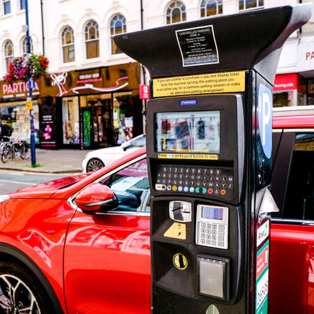 Red Car Parked Next To A Modern Parking Meter, With No People