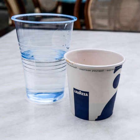 London UK October 19 2020, Disposable Paper Cup Of Lavazza Espresso Coffee And A Glass Of Water With No Peopleのeditorial素材