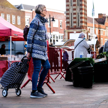London UK, November 12 2020, Senior Woman Pulling Shopping Trolley Walking Alone During Coronavirus...