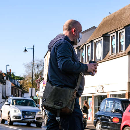London UK, November 15 2020, Man Holding Takeaway Coffee Crossing The Road Wearing Face Covering During COVID-19 Coronavirus Lockdownのeditorial素材