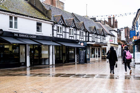 London UK, March 26 2021, Two Woman Or Students Walking Down An Empty High Street In The Rain