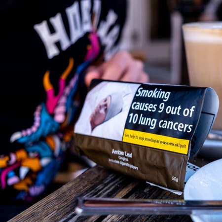 Epsom Surrey, London England UK, April 23 2021, Packet Of Rolling Cigarette Tobacco Next To A Latte...