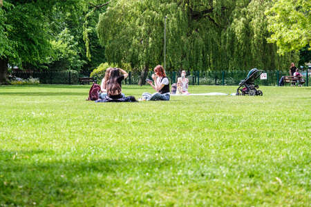 Epsom Surrey, London, May 09 2022, Groups Of Young People Sitting On The Grass In A Park Relaxing And Talkingのeditorial素材
