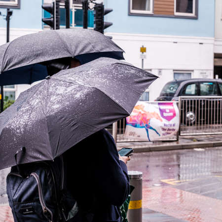 Epsom Surrey, London UK, June 04 2022, Men Sheltering Under Umbrellas On A Wet Rainy Dayのeditorial素材